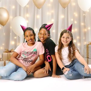 Three girls in birthday hats with balloons